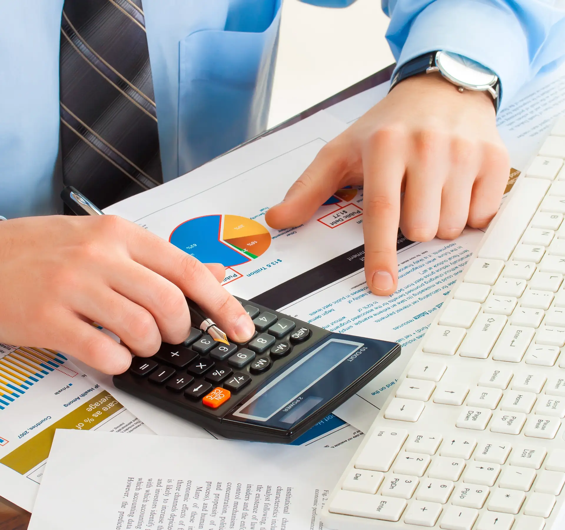 Businessman using calculator and keyboard